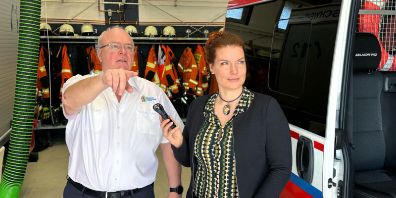 Zwei Menschen, die sich in einer Feuerwehrhalle unterhalten