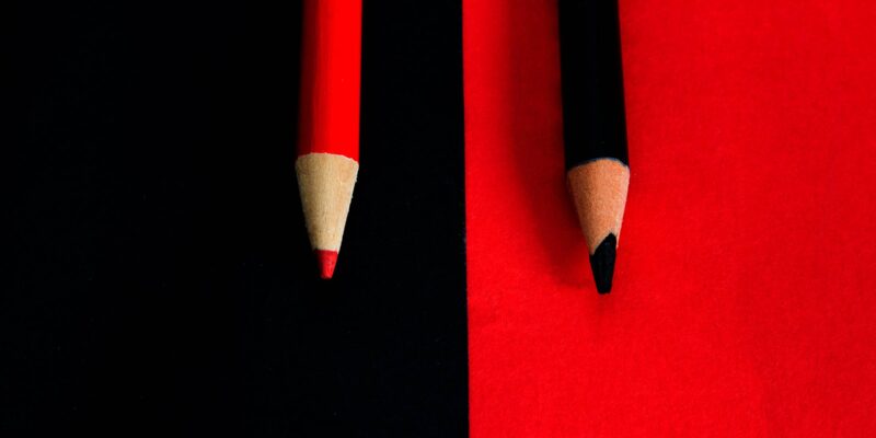 Bleistiftspitzen auf farbigen Hintergründen, roter Stift auf schwarz, schwarzer Stift auf rot (Foto: carlofornitano (iStock))
